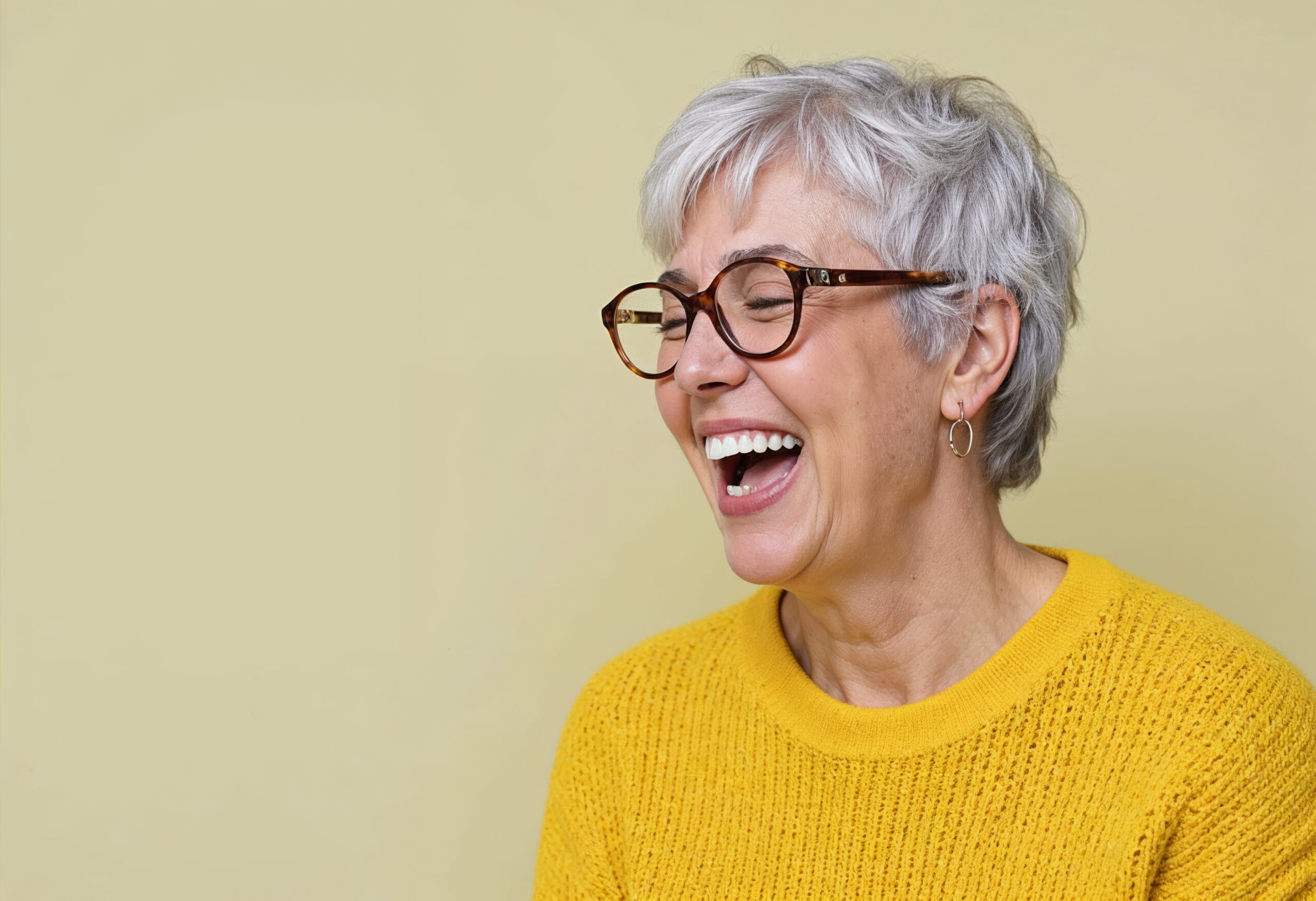 A smiling woman in thick framed glasses.